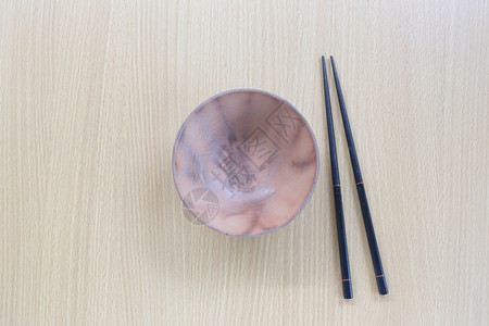 在设计概念食物的木本背景上黑筷子和碗放在顶层视线上背景图片