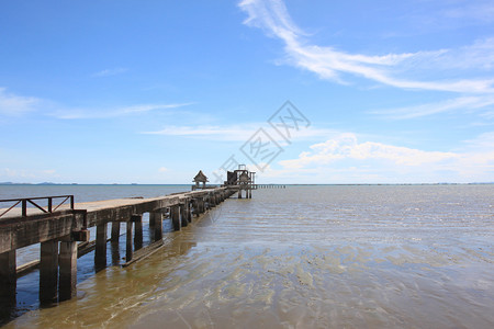 混凝土桥延伸至海岸和干水中阳光明媚蓝天背景泰国的海边图片