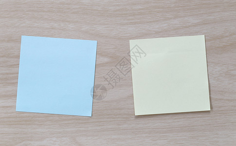 放在木制地板上的Note蓝纸和黄色设计思想可视需要输入您的信息图片