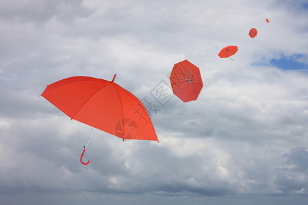 红伞被风吹散管理商业概念的有关雨云背景背景图片