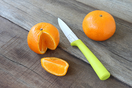 放在木制地板上的新鲜橙子水果具有用于健康饮食概念的刀片丙烯酸图片