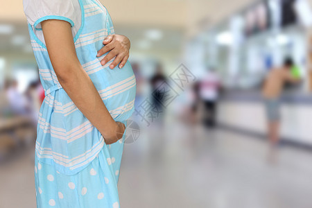 孕妇在医院背景下穿着蓝色孕妇装背景图片