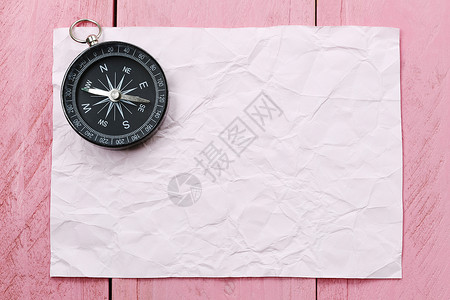 粉红色木地板上的指南针和纸旅行出的概念背景图片