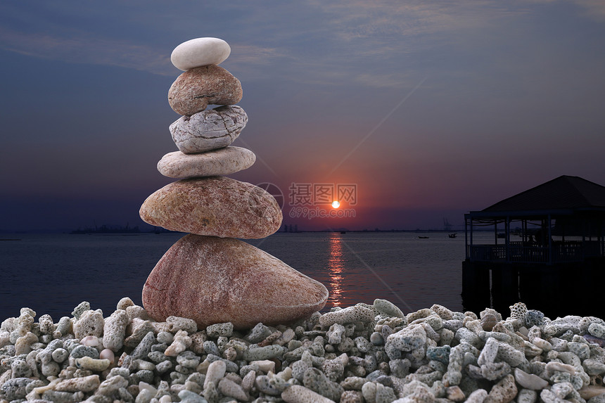 夜晚日落背景的堆石上平衡和概念赞图片