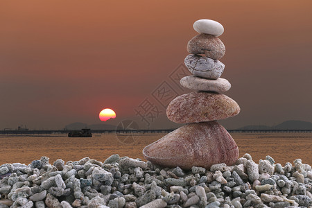 夜晚日落背景的堆石上平衡和概念赞图片