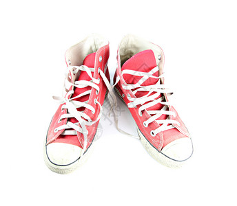 白色背景上隔离的肮脏红色运动鞋高清图片