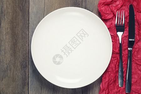 空白的盘子上面有银叉和勺子红纸艺术在木地板上欢乐的庆祝时间概念图片
