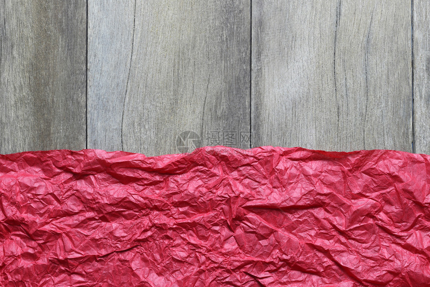 在棕色木地板背景上折叠的红色艺术纸并有复制的空间来设计你的工作圣诞概念图片