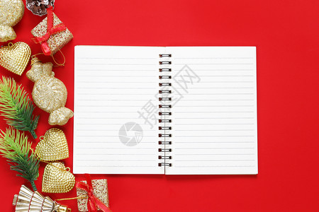 圣诞装饰和红色背景的空笔记本设计成你的工作概念图片