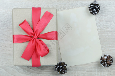 棕色礼物盒红弓在木制地板上空白书在圣诞节和新年概念你的设计图片