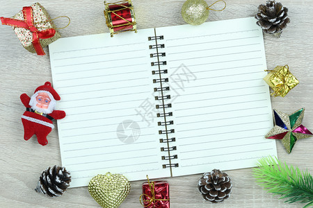 在木地板和空白书上设置圣诞和新年装饰品供您在工作概念中设计图片