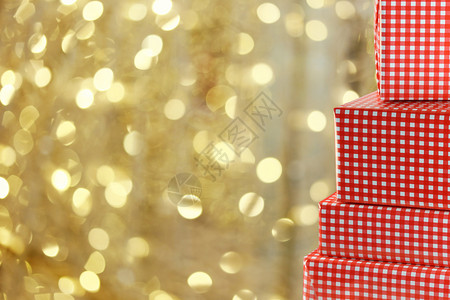 尔滨你变了红礼物盒放在圣诞灯的金布基背景设计在你的圣诞节概念设计图片