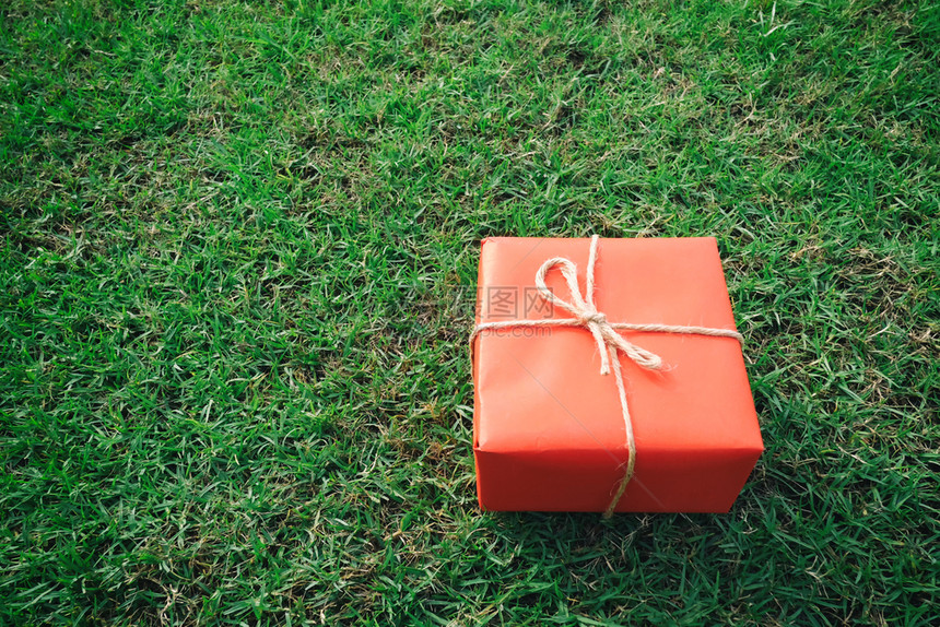 圣诞新年情人节或周纪念日绿草坪上的红礼盒图片