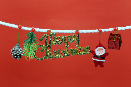圣诞老人娃挂在衣绳上并有复制空间红色背景设计你的工作概念图片