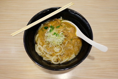 饭桌上的碗里有拉门咖喱和日本人一起的大众食品图片