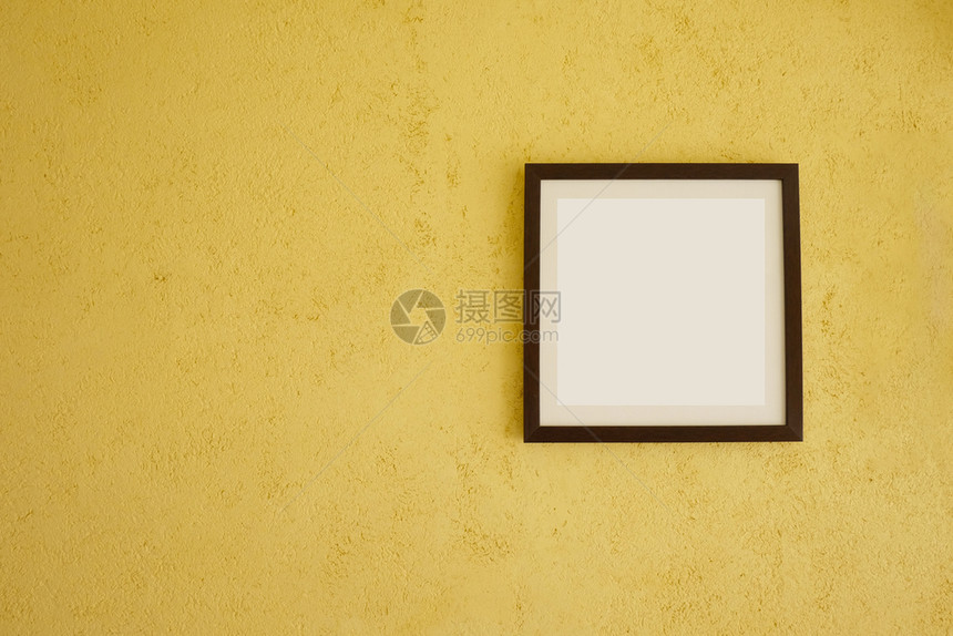 在古老的黄色墙壁上空图片框并复制您在工作概念中的设计空间图片