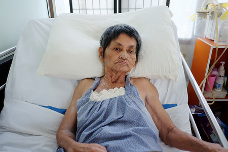 亚洲老年妇女躺在床上生病对退休后健康的看法图片