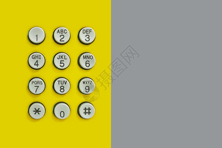 黄色背景的电话数字键盘在技术背景下设计时有灰纸背景图片