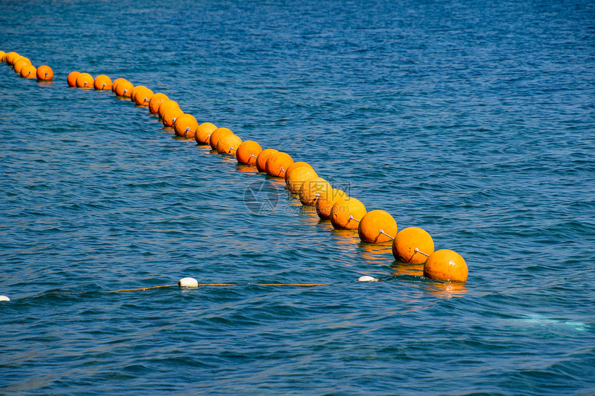 海上一条绳子的橙色浮标海上游泳的栅栏图片