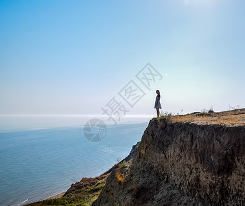 女孩站在海边悬崖上图片