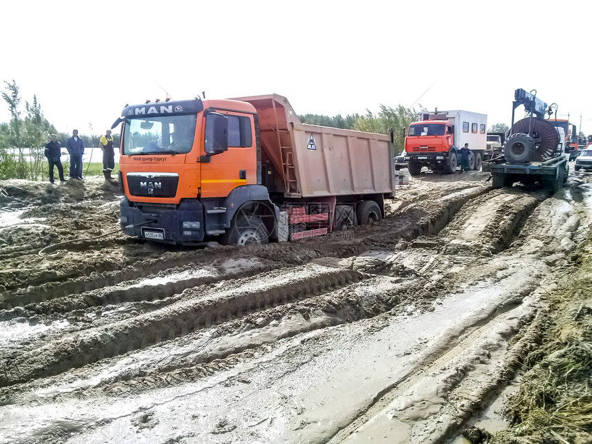 俄罗斯KhantyMansiysk附近的石油和天然气田2017年9月5日泥土路上的卡车路上的卡车图片