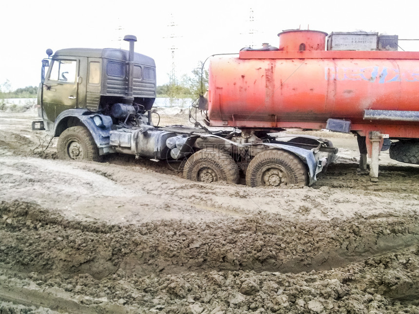 俄罗斯KhantyMansiysk附近的石油和天然气田2017年9月5日泥土路上的卡车路上的卡车图片