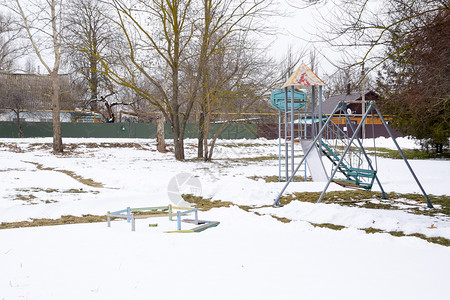 冬季儿童游乐场在雪下摇摆旋转木马和滑动冬季荒凉图片