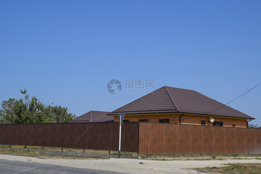 一栋房屋有金属顶用棕色金属壁画制成的栅栏一栋房屋用棕色金属壁画制成的栅栏图片