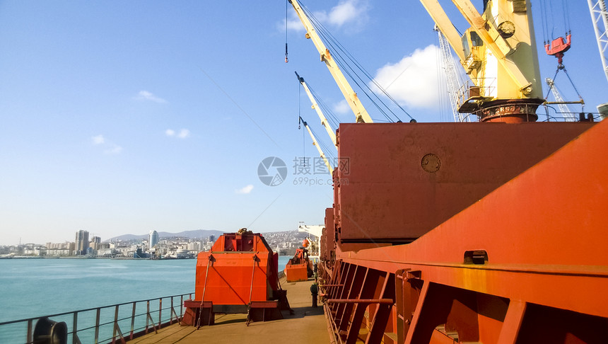 港口码头海和城市滩的景象工业港口有塔起重机和货物基础设施图片