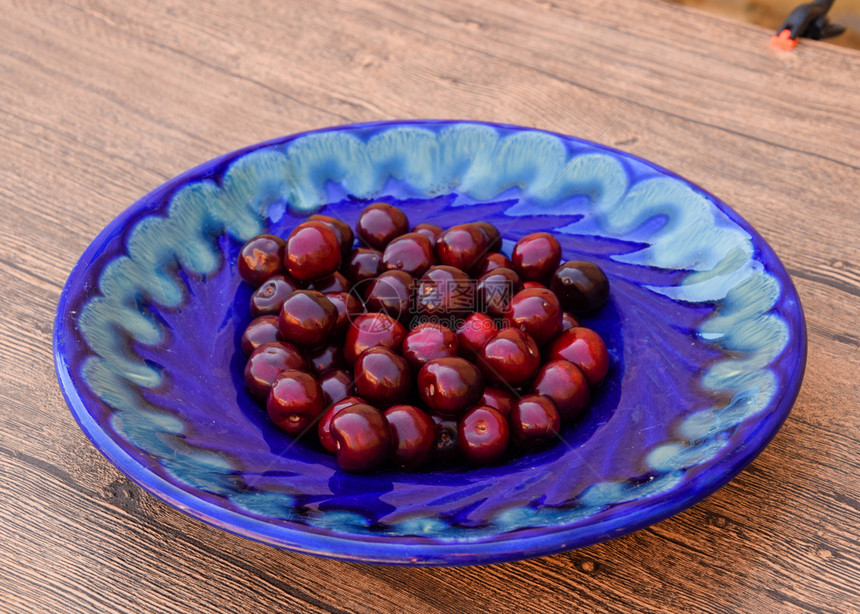 蓝盘子里甜樱桃的浆果成熟的红甜樱桃蓝盘子里甜樱桃的浆果成熟的红甜樱桃图片