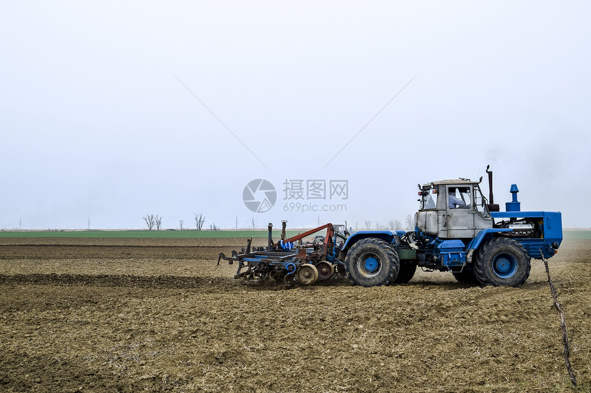 播种前要把地上的土壤肥沃松软拖拉机用犁耕地播种前要把地上的土壤肥沃松软拖拉机用犁耕地图片