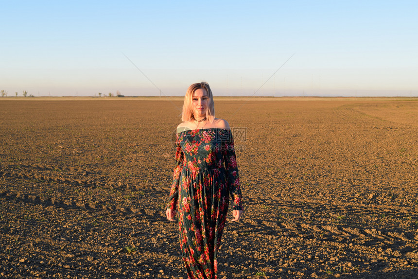 穿着日落背景的红黑礼服女人图片