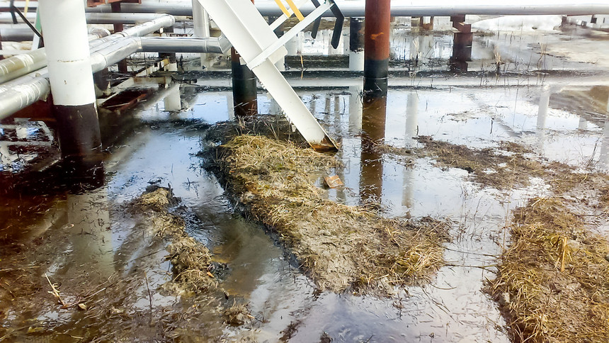 管道和加工设备附近的沙土壤上漏油操作和维修期间漏油管道和加工设备附近的沙地土壤上漏油操作和维修期间漏油图片