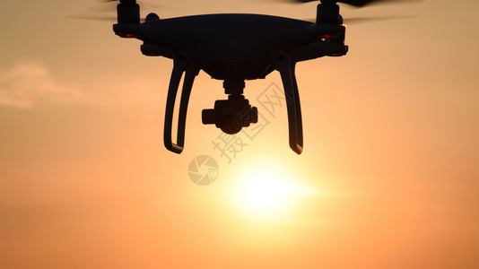 日落背景下的无人飞机背景图片