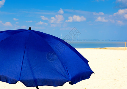 海和天空背景的蓝色纺织伞带白云复制空间图片