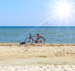 夏日旧红色自行车在海上站立图片