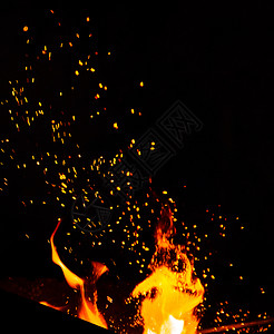 燃烧着烈火黑背景的橙色和黄火花柱上升图片