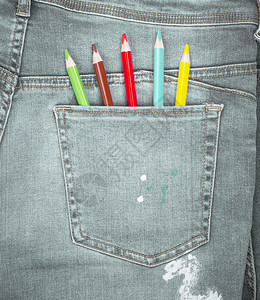 蓝牛仔裤后口袋的彩色铅笔全框图片