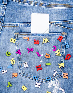散在蓝色牛仔裤上的彩木字母在后口袋内一张空白卡背景图片