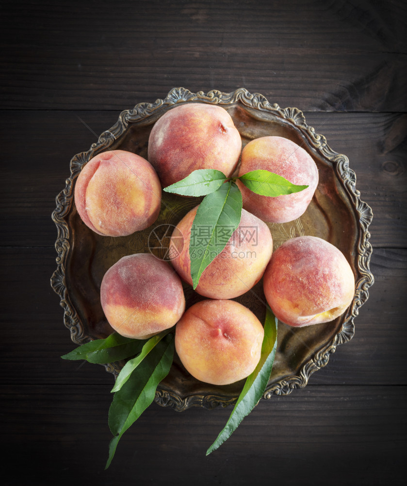 圆铁板上最顶端风景的新鲜熟桃子图片