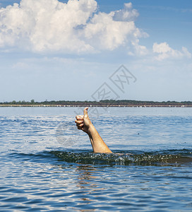 男子的手棍从水中伸出来表现像夏日那样的姿态图片