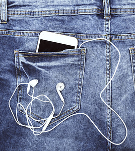 白智能手机耳在蓝色牛仔裤的后口袋图片