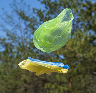 空塑料袋在夏日穿过绿草地对环境造成污染图片