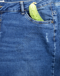 绿色黄瓜躺在蓝牛仔裤前口袋里整个框架图片