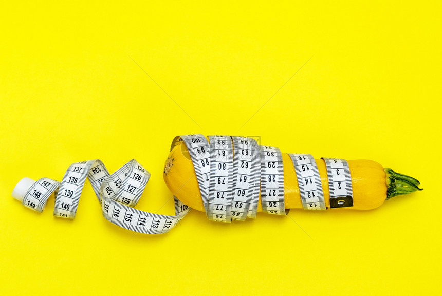 黄的青尼包裹在测量胶带中体重减肥概念图片