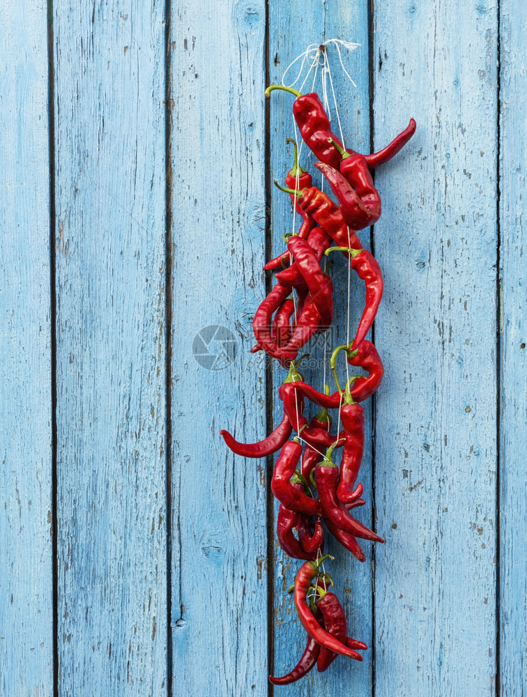 挂在绳子上的辣椒蓝色的老木背景复制空间图片