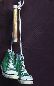 一对古老的绿色经典运动鞋挂在白色蕾丝上关图片