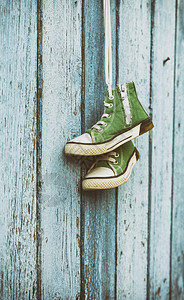一对古老的绿色经典运动鞋挂在白色的蕾丝上图片