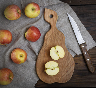 成熟的红苹果砍木板和桌上的刀子图片