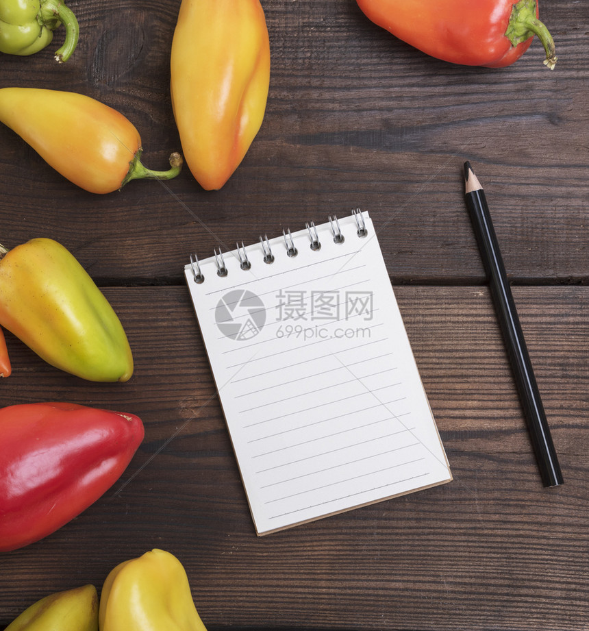 在新鲜胡椒蔬菜中用黑木铅笔在棕色桌上用白纸笔图片